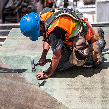 A construction worker is on the ground working.