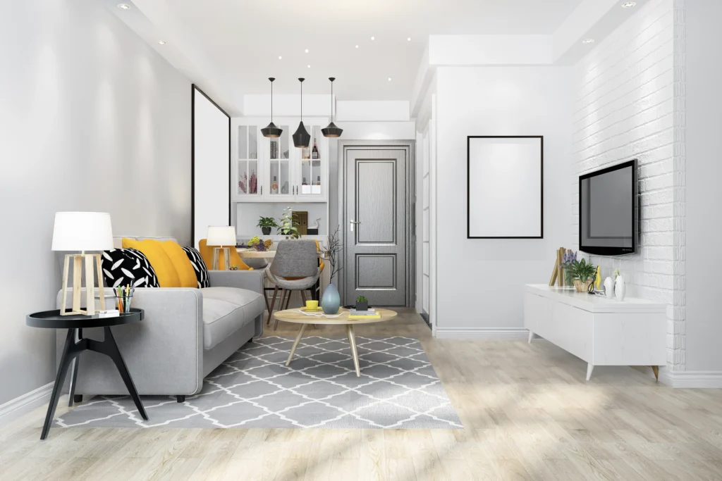 A living room with white walls and grey furniture.