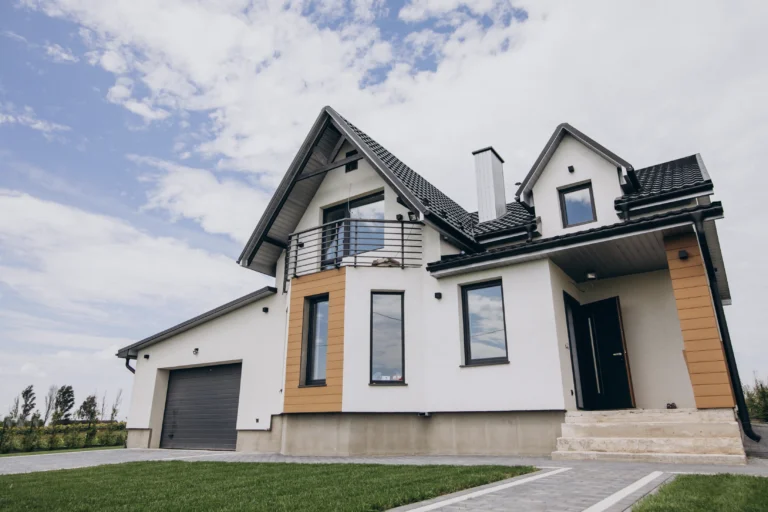 A large white house with a balcony and garage.