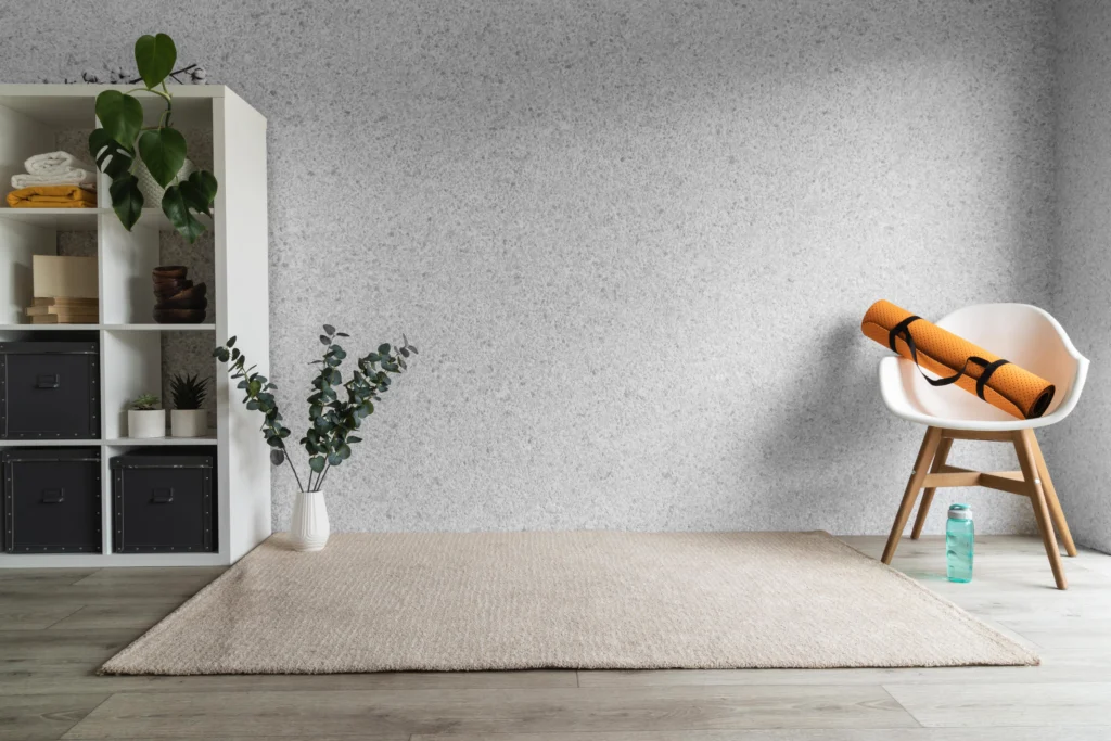 A white rug in front of a wall with plants.