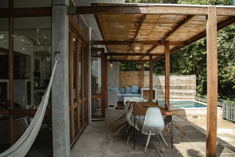 A patio with tables and chairs under an awning.