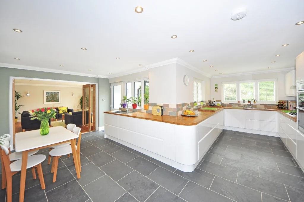 A kitchen with white cabinets and wooden counter tops.